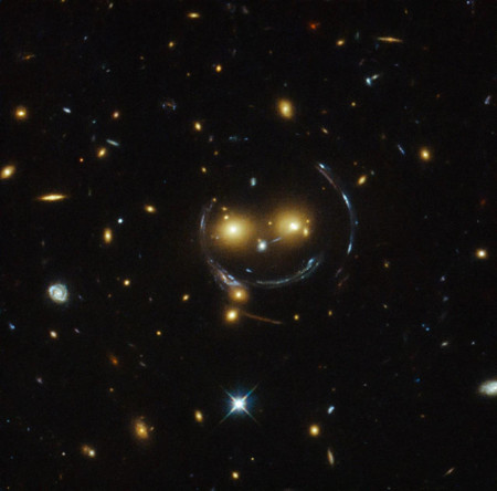 A SMILEY FACE. Formed by gravitational distortion and the angle we see the galaxies at