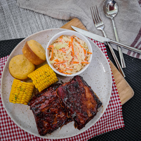 Oven pork ribs with cornbread muffins, buttered corn, and coleslaw