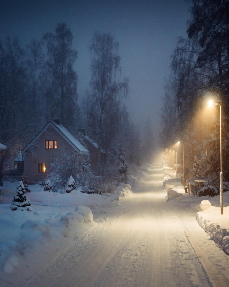 Snow-covered road lit with street lights, Finland