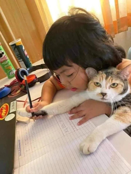 A girl teaching her cat how to write 🐱 💘