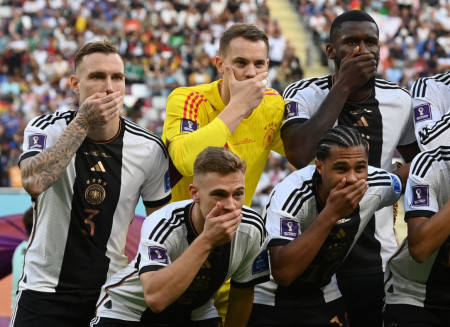 Germany players cover mouths in team photo as they abandoned pro-LGBTQ armband. FIFA threatened yellow cards for any player still wearing it