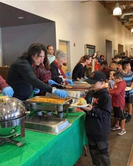 Alice Cooper serving food to children in need at his restaurant, Alice Cooper&#039;s town, during Christmas time