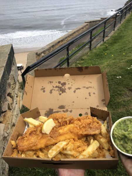 Crispy and fresh fish and chips with a side of mushy peas