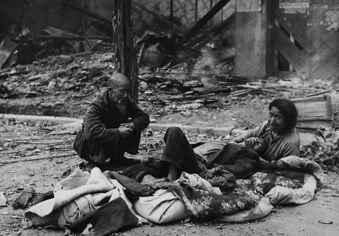 Civilians huddle in the streets of Seoul, South Korea amid rubble and debris, after fierce fighting between UN and North Korean forces, during the Korean War - 1950