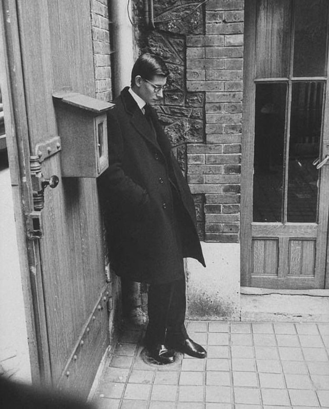 Christian Dior’s successor Yves Saint Laurent standing alone after attending Dior’s funeral, Paris 1957