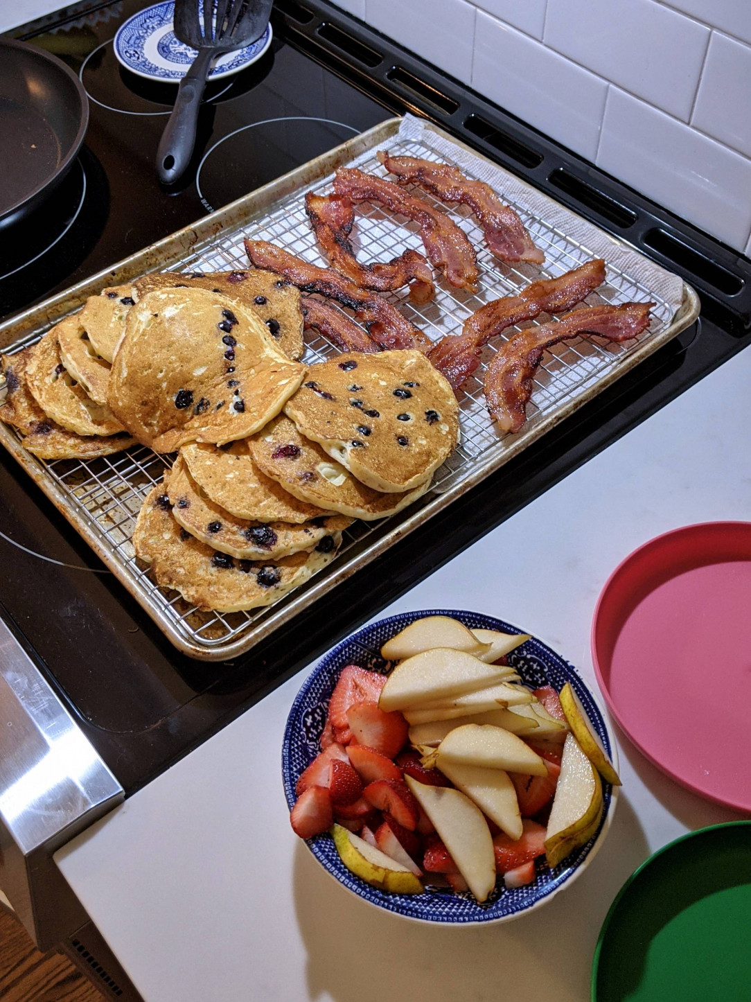 Breakfast for dinner: blueberry pancakes, bacon, and fresh pears and strawberries