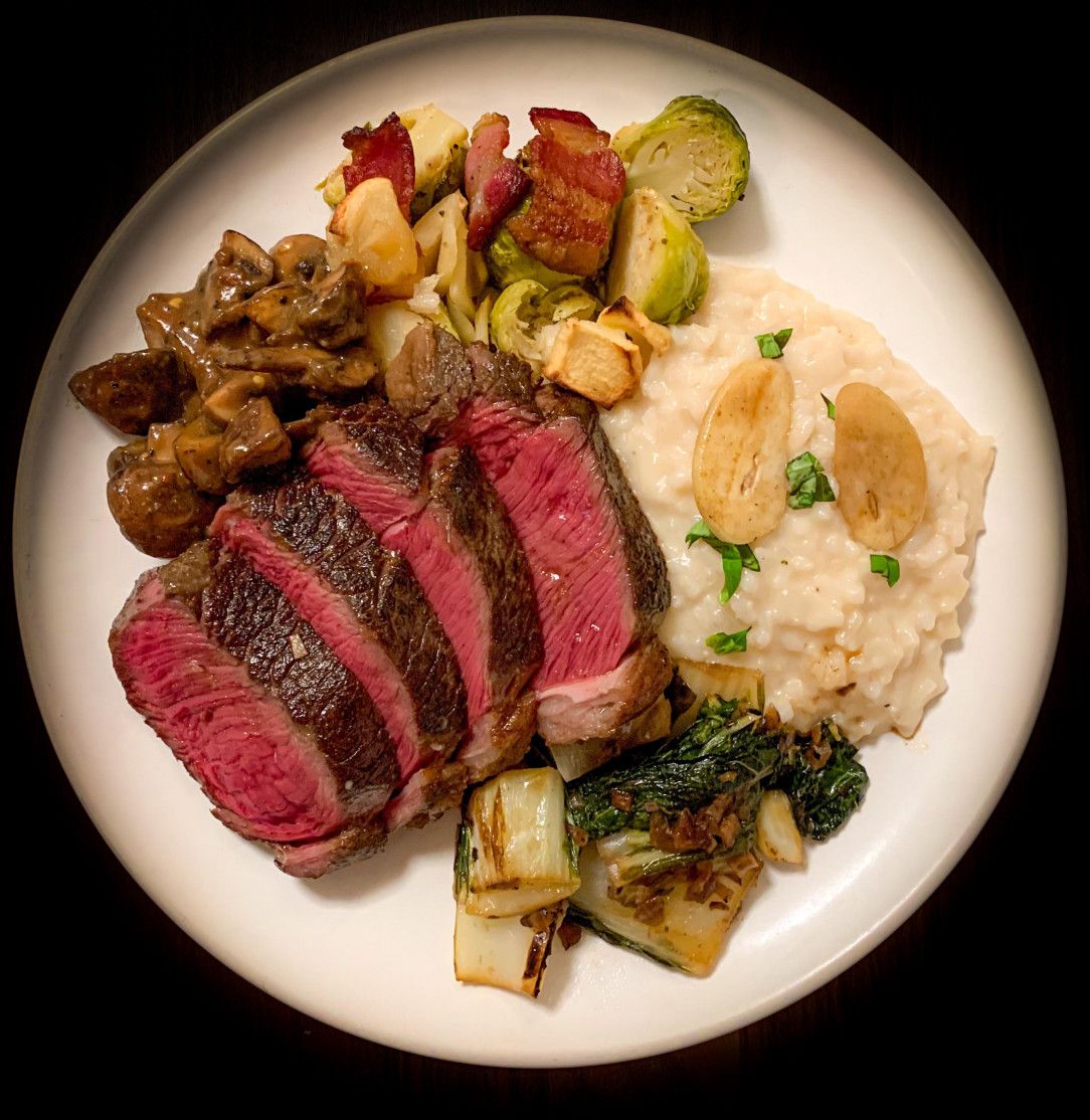 Sirloin, giant garlic and basil risotto, mushroom gravy, brussels, charred bok choy. OC. Dinner