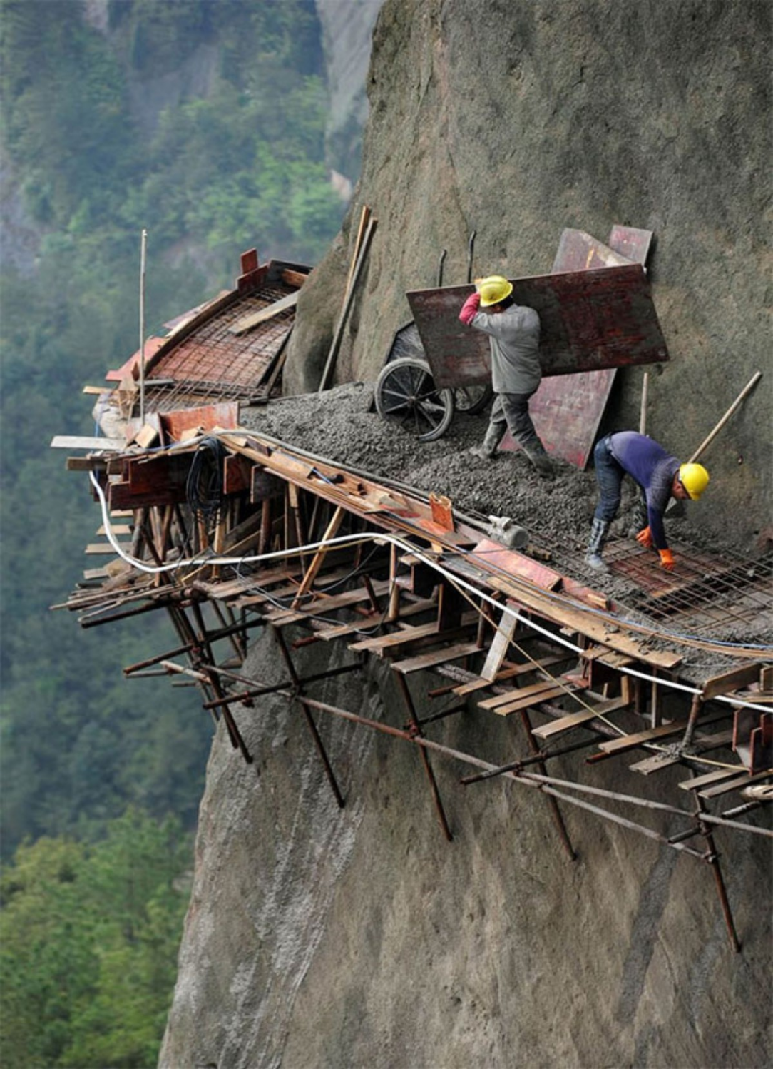 Daredevil works for Chinese builders working on a road in the mountains of Pingjiang County, Hunan province 😵😱
