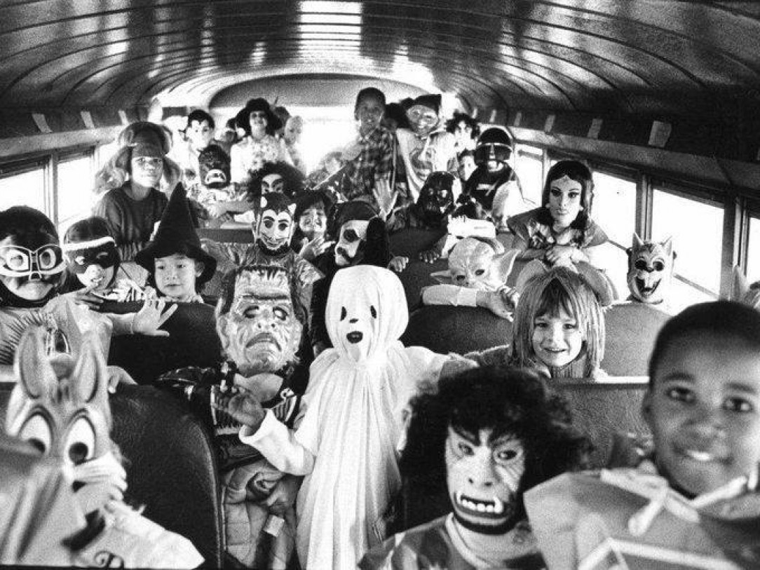 Kids dressed for Halloween on a school bus. 1980s