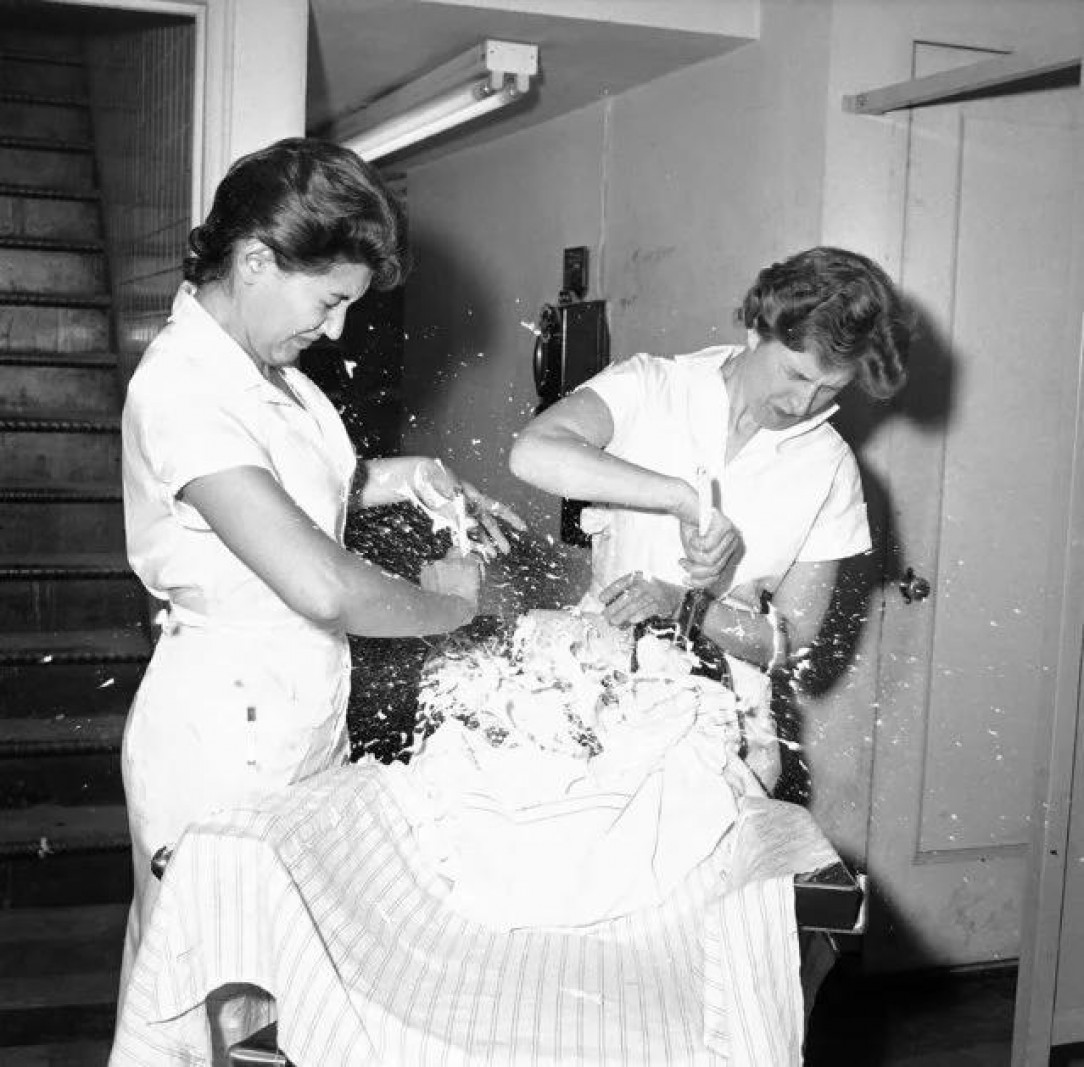 Barber school students attempt shaving a balloon, 1959