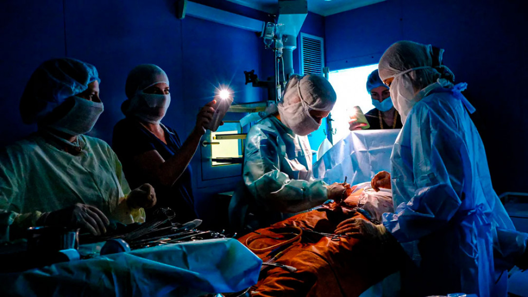 Kyiv surgeons operating on a patient using phones for lights during a blackout caused by Russian strikes at civil infrastructure