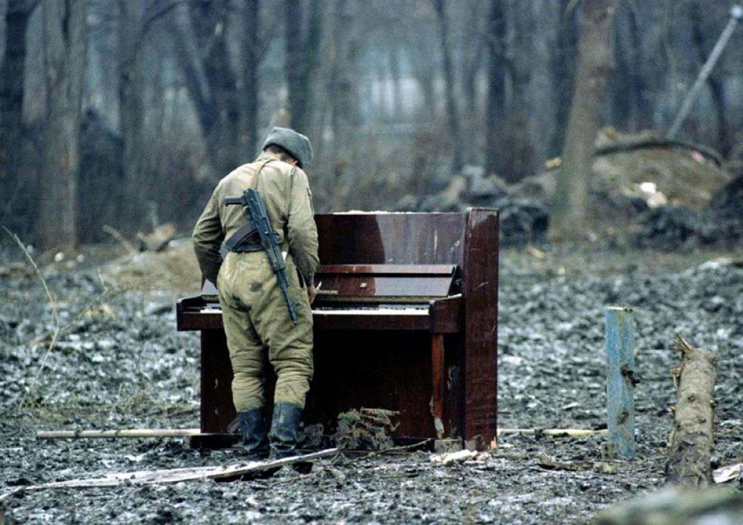 A Russian soldier playing an abandoned piano in Chechnya in 1994
