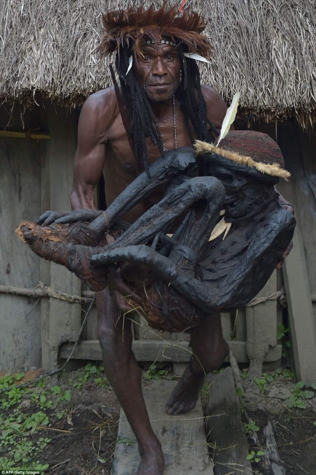 Chief Eli Mabel in Papua holding his mummified ancestor