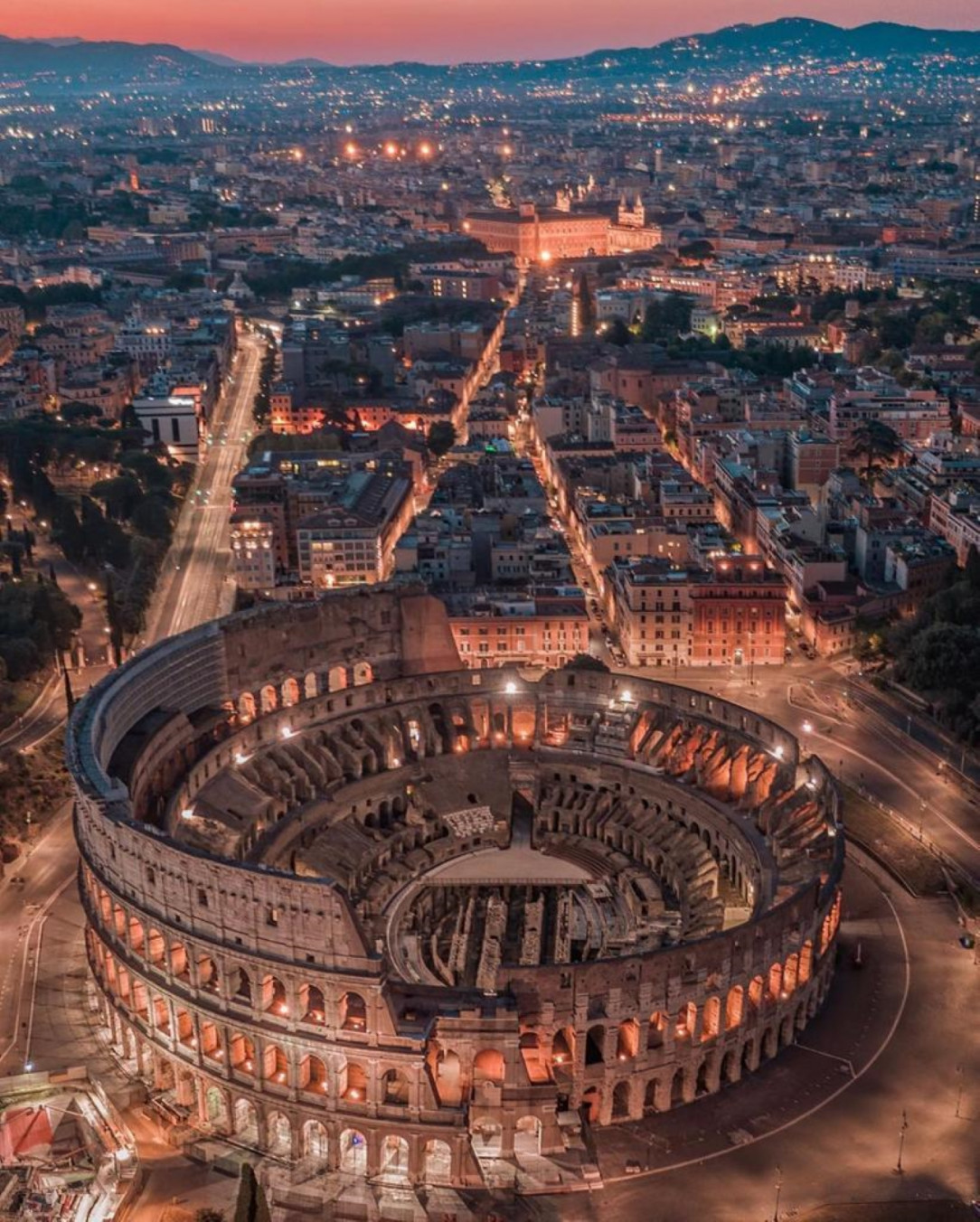 The Colosseum at Regio III Isis et Serapis and the city of Rome in Italy‎ at Night