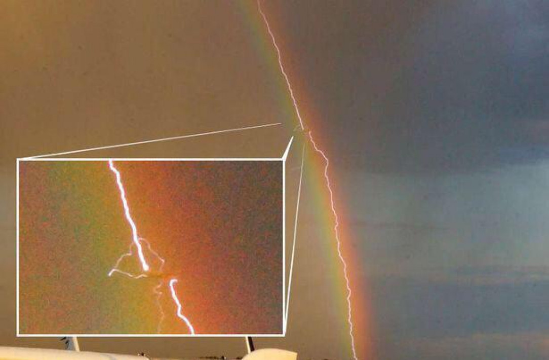 Plane struck by lightning over a rainbow