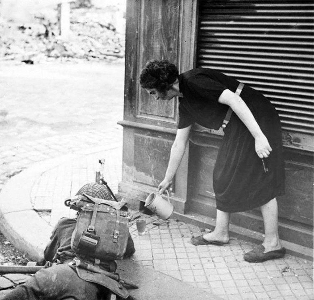 French woman pouring tea for a British soldier fighting in Normandy 1944