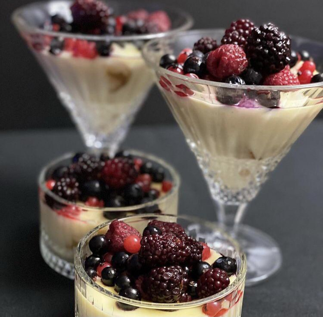 Vanilla-lemon pudding with berries on top and crushed melba toasts on the bottom