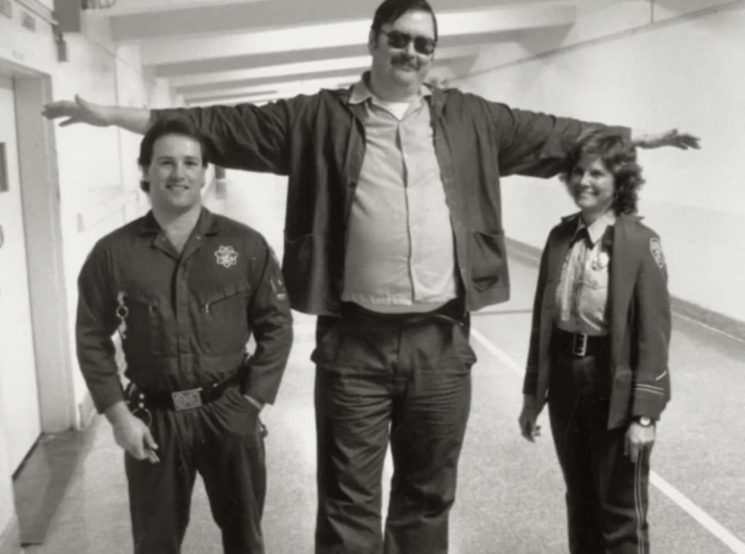 Two prison guards posing for a photo with Ed Kemper, who was 6’9 and 300lbs