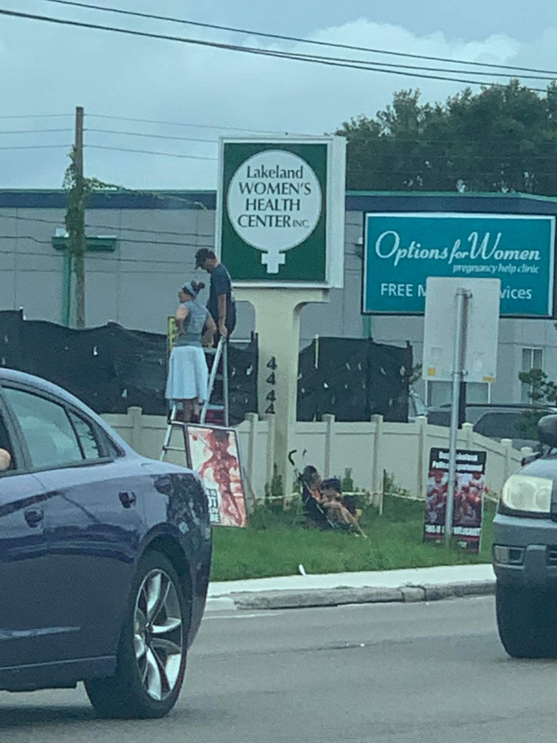 Abortion Protestors using a ladder to harass people over the privacy screen