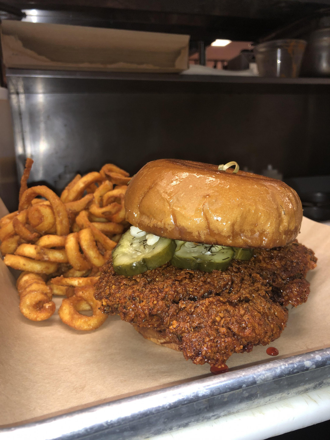 Thai spiced, Nashville inspired, hot chicken sandwich with homemade garlic dill pickles and curly fries