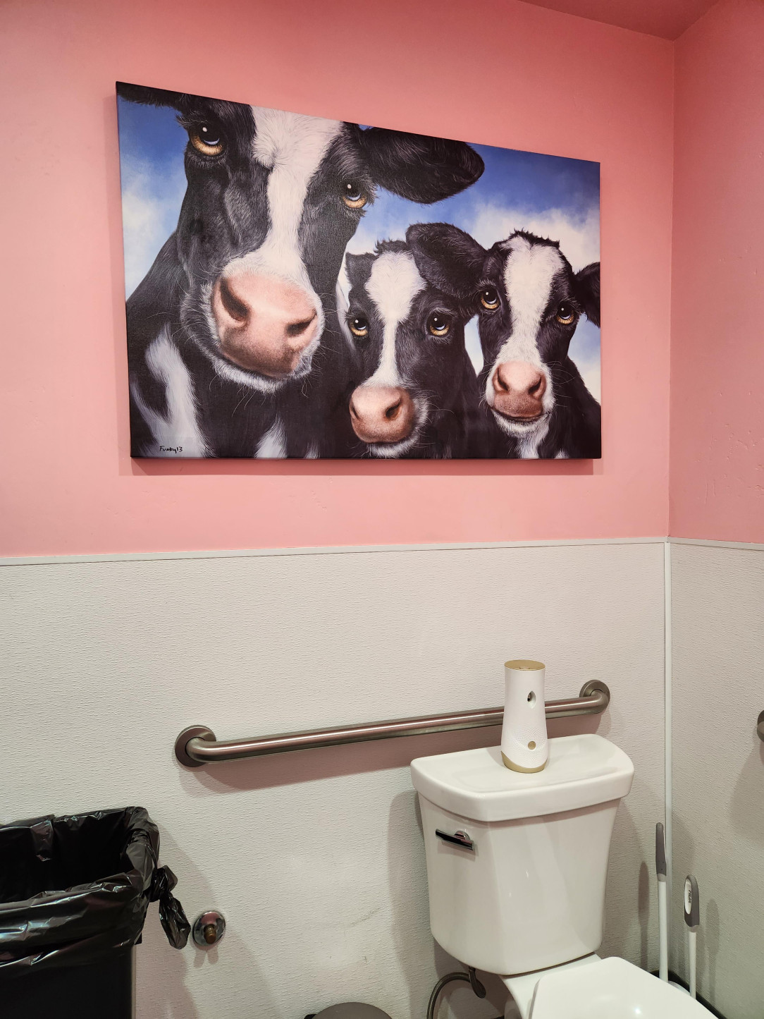 A cow painting in the bathroom of an ice cream shop