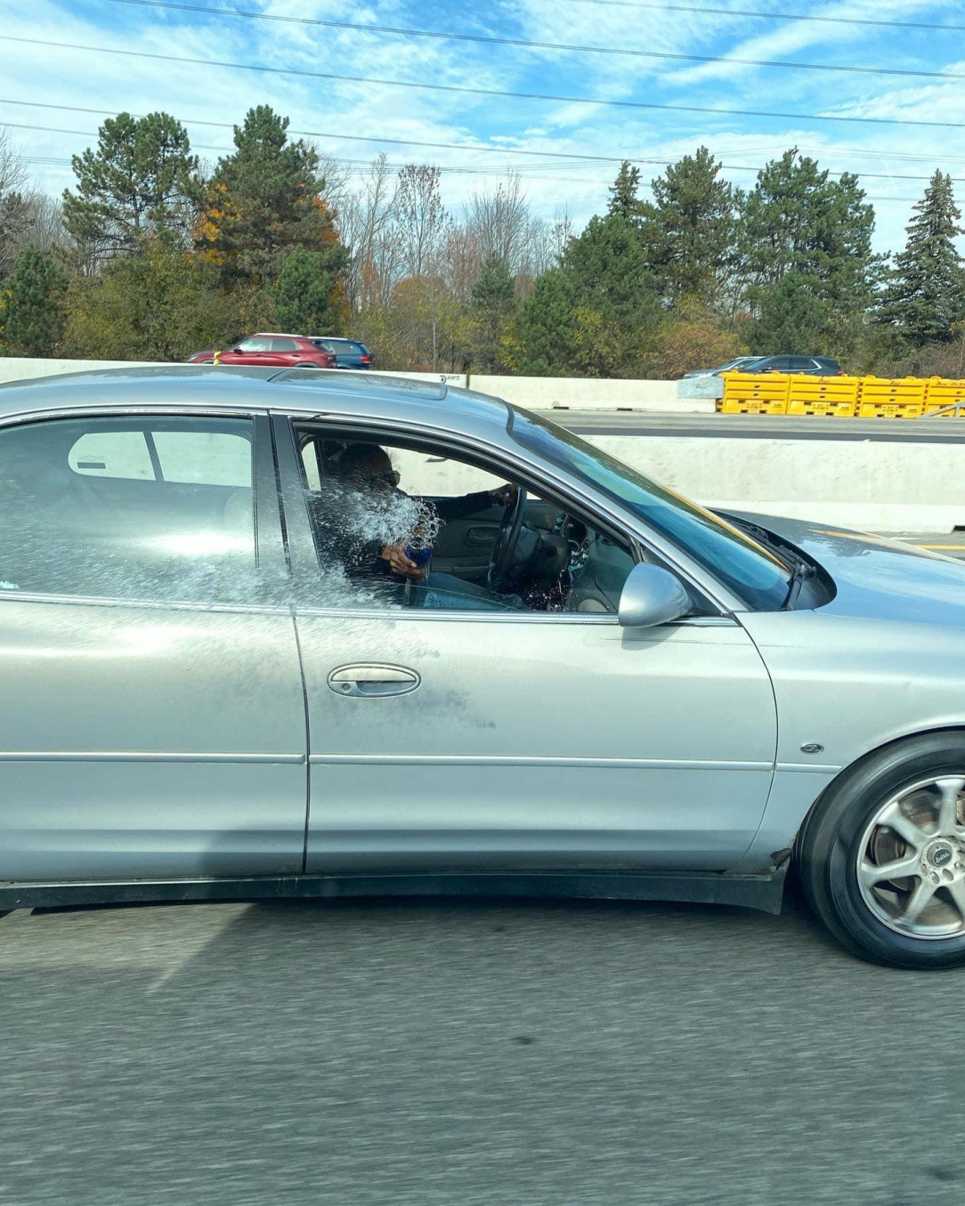 Trying to toss water at a car that passed her. Gave her own interior a nice bath